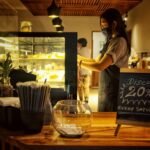 A cafe scene with a barista and discount chalkboard, creating a welcoming atmosphere.